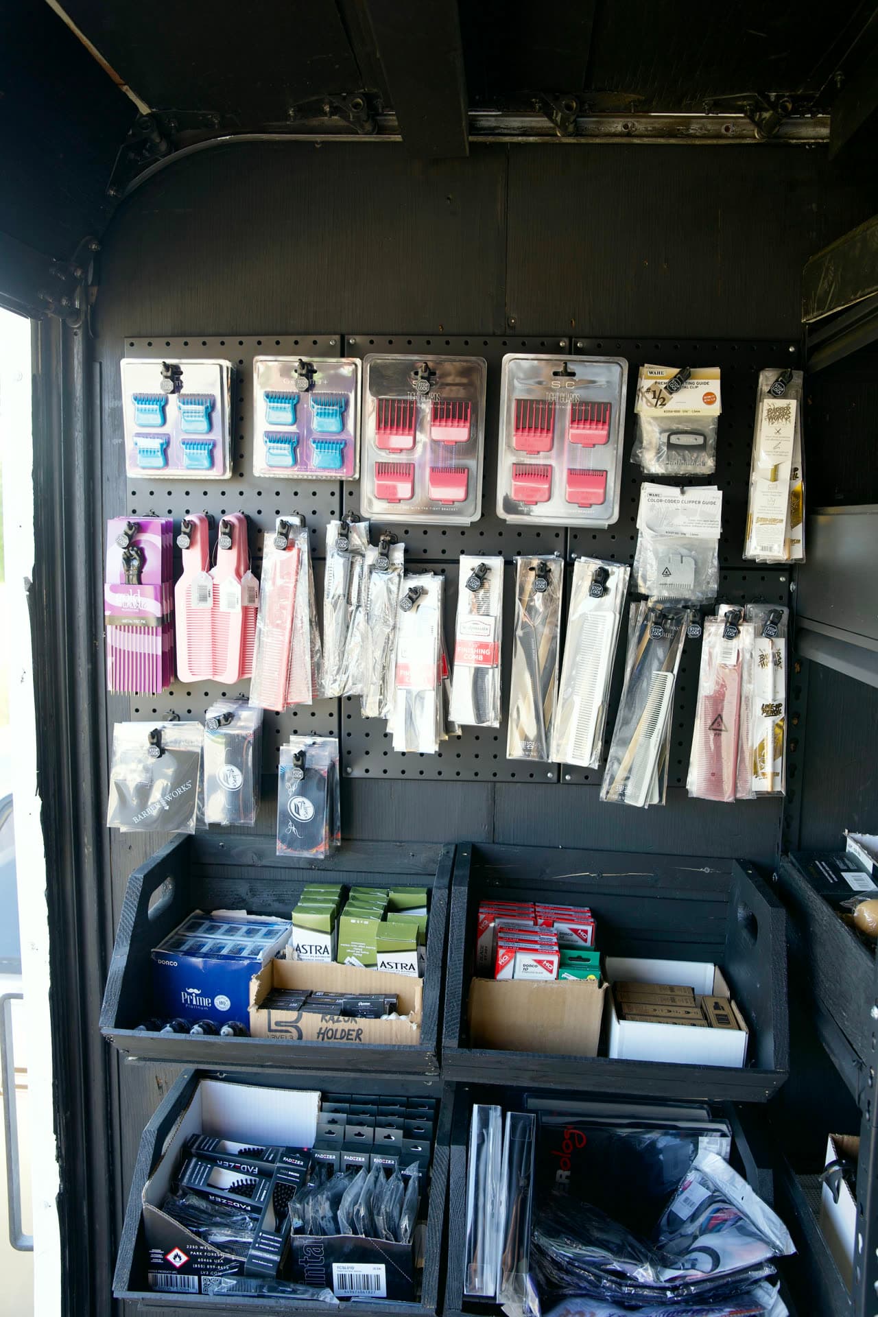 Pegboard of clipper guards, combs, razors and blades in the trailer
